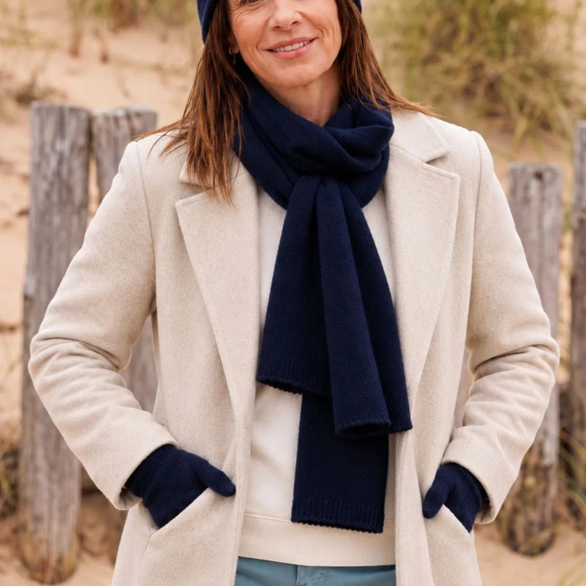 Femme en manteau crème portant une écharpe en cachemire et laine Marine Léman nouée et les gants assortis – PALÂBA