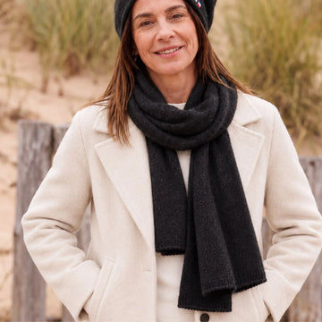 Femme en manteau blanc portant une écharpe en cachemire et laine Noir Val d'Isère et le bonnet assorti – PALÂBA