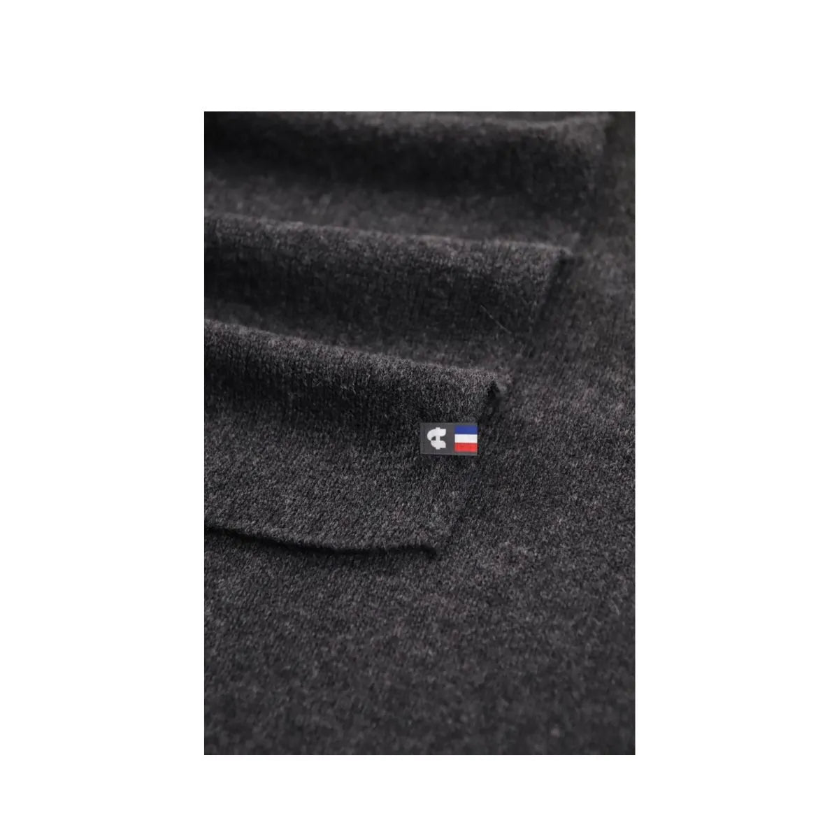 Détail de la maille d'une écharpe en cachemire et laine Noir Val d'Isère avec son étiquette tricolore – PALÂBA