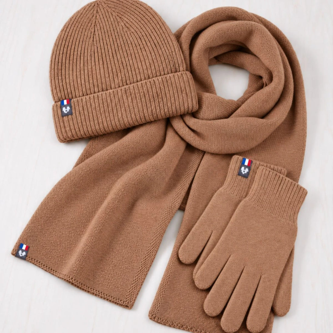 Homme barbu portant l'ensemble bonnet, écharpe et gants en laine mérinos Camel Aubrac dans les dunes – PALÂBA