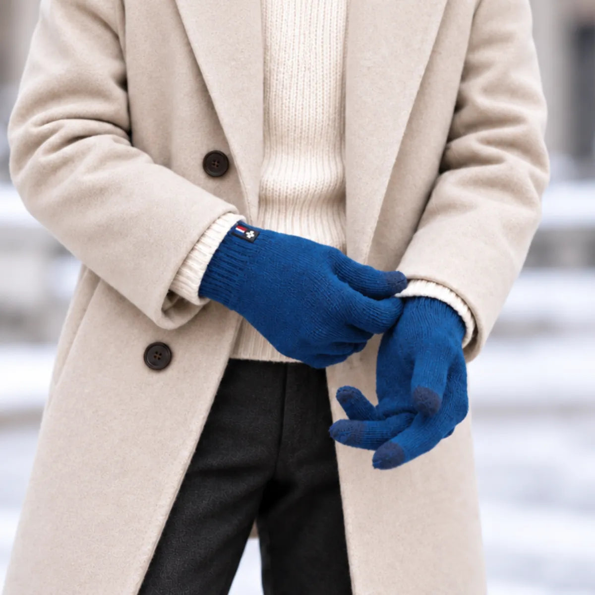 Homme en manteau beige enfilant des gants tactiles en laine mérinos Bleu Paon Verdon, bouts des doigts tactiles visibles – PALÂBA