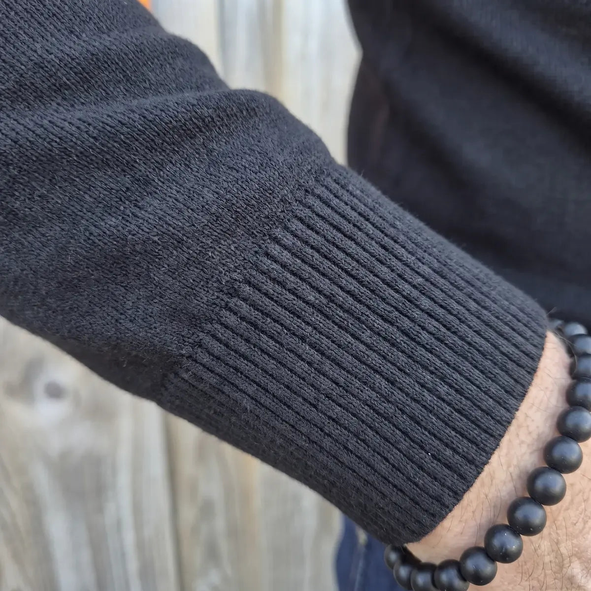 Poignet en bord-côte du pull noir en laine mérinos, maille fine jauge 12 – PALÂBA